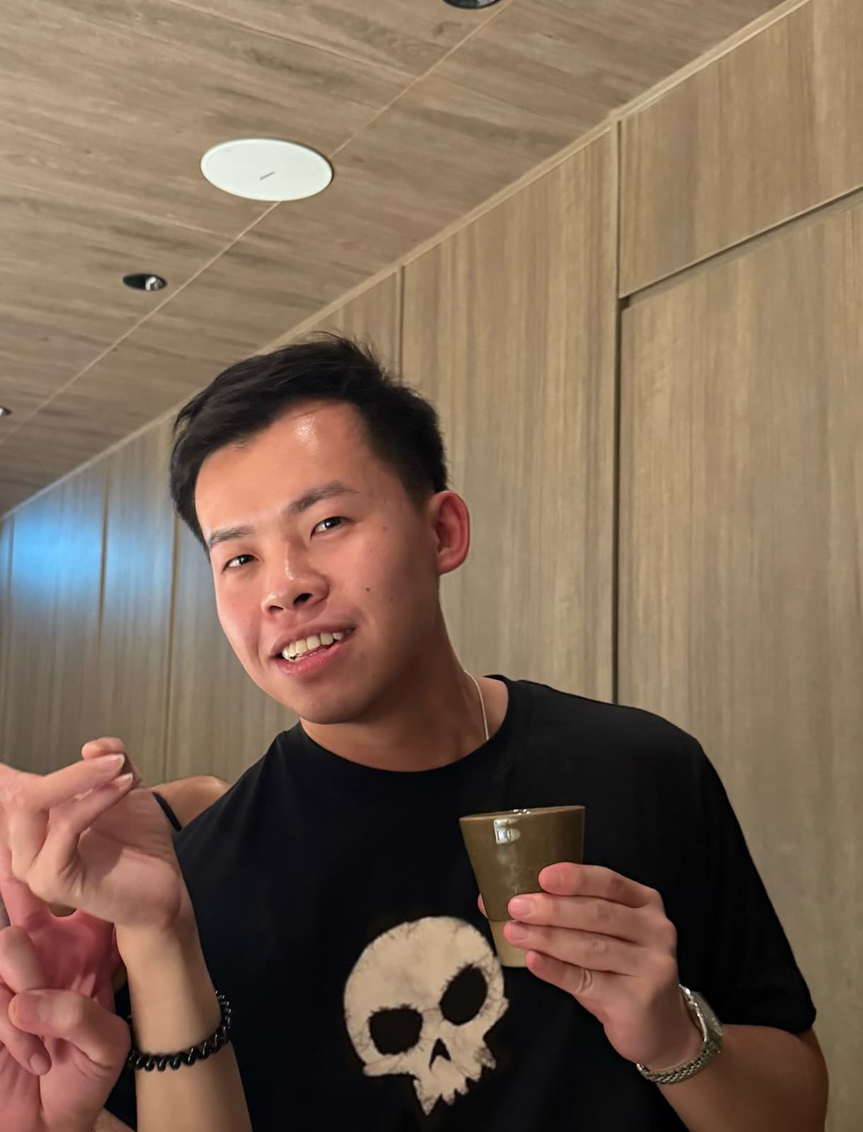 Alex Chan holding a cup indoors