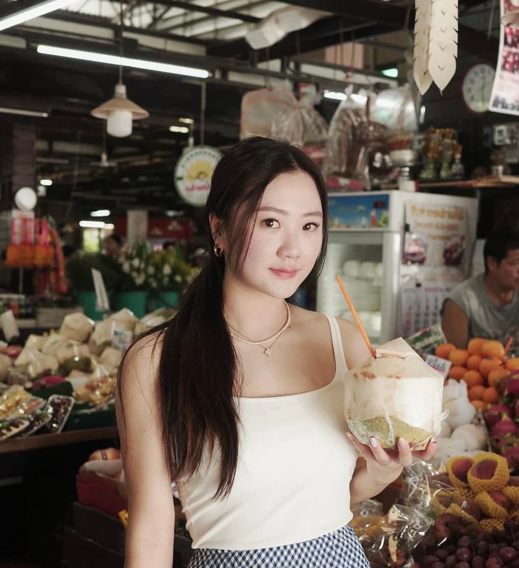 Cherry Wong holding a coconut at a market