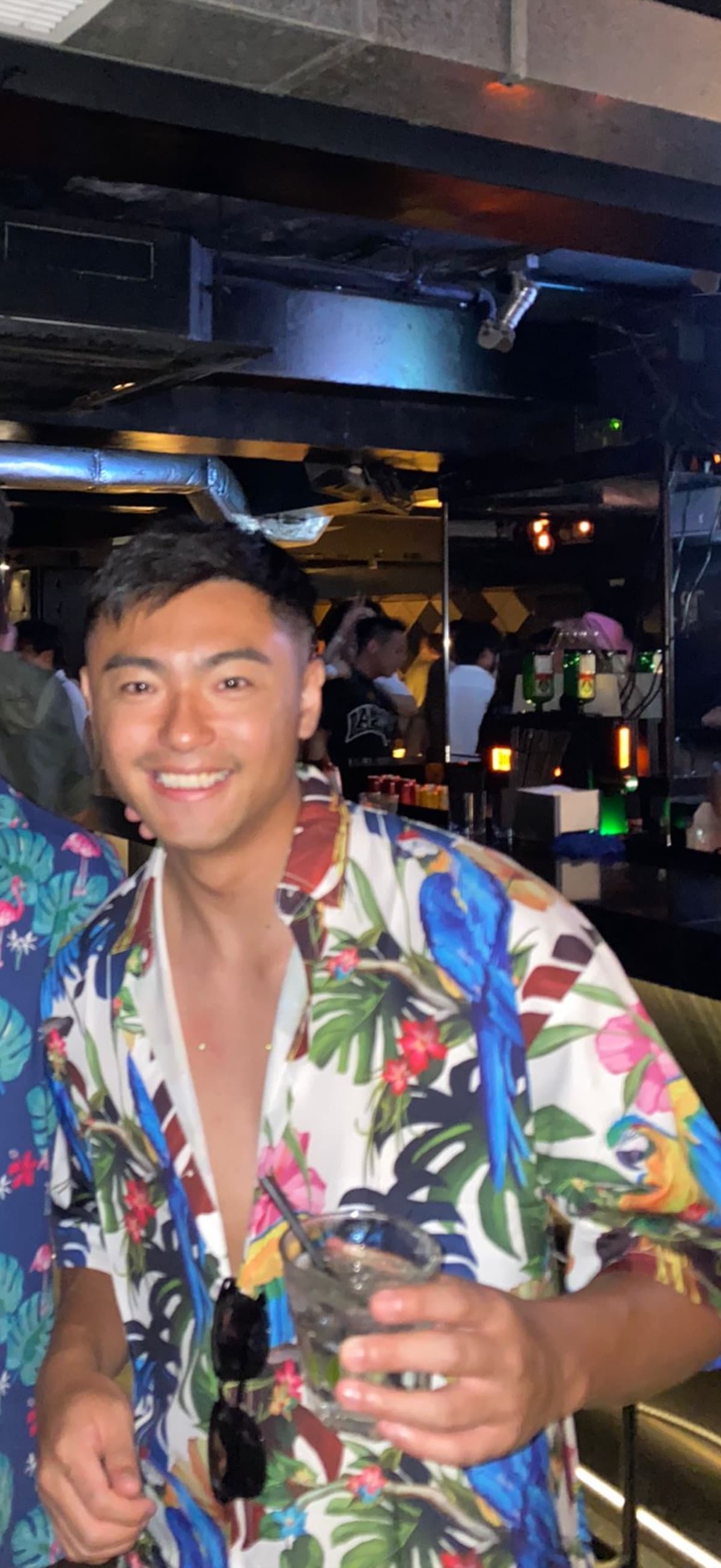 Jackal Leung holding a drink at a nightclub
